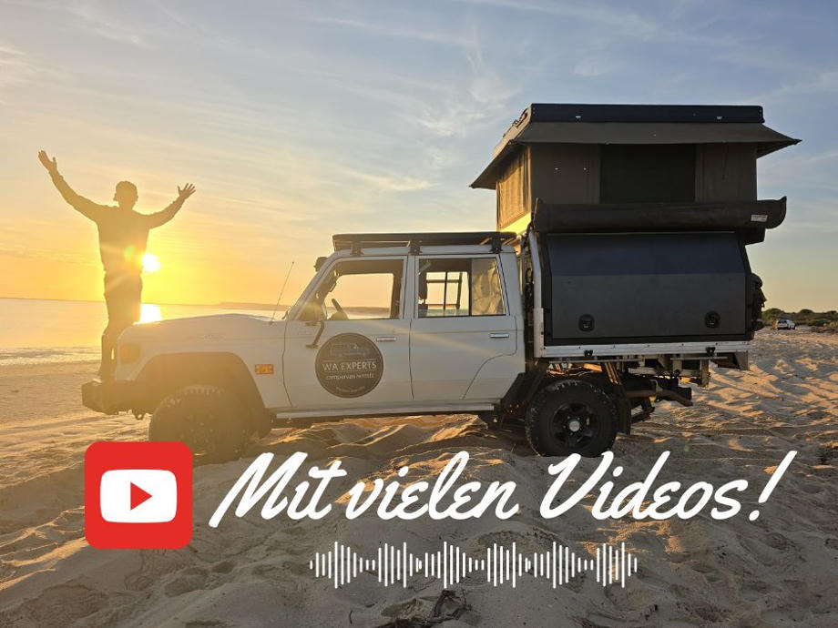 Ein Camper mit Dachzelt auf einem Sandstrand