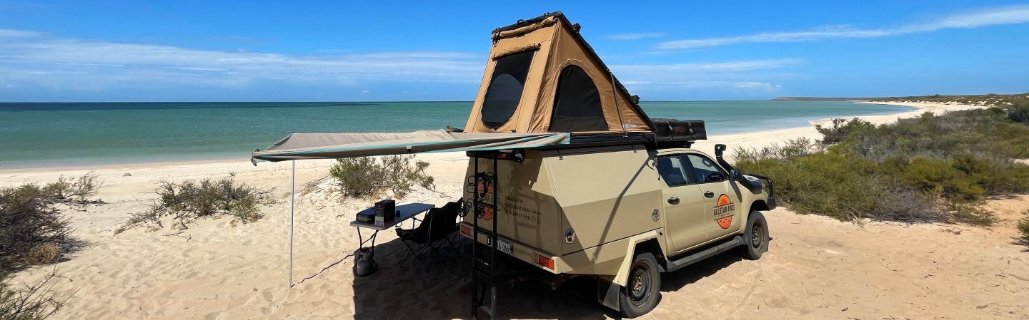 Allstar Camper Hire 4WD Fahrzeug steht am Strand