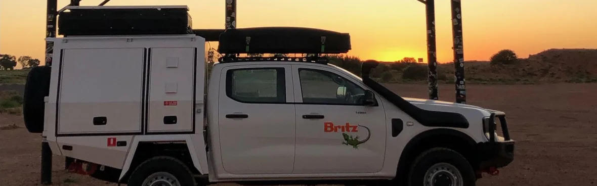 Der Warrior von Britz Rentals auf Sand geparkt bei Sonnenuntergang in Australien
