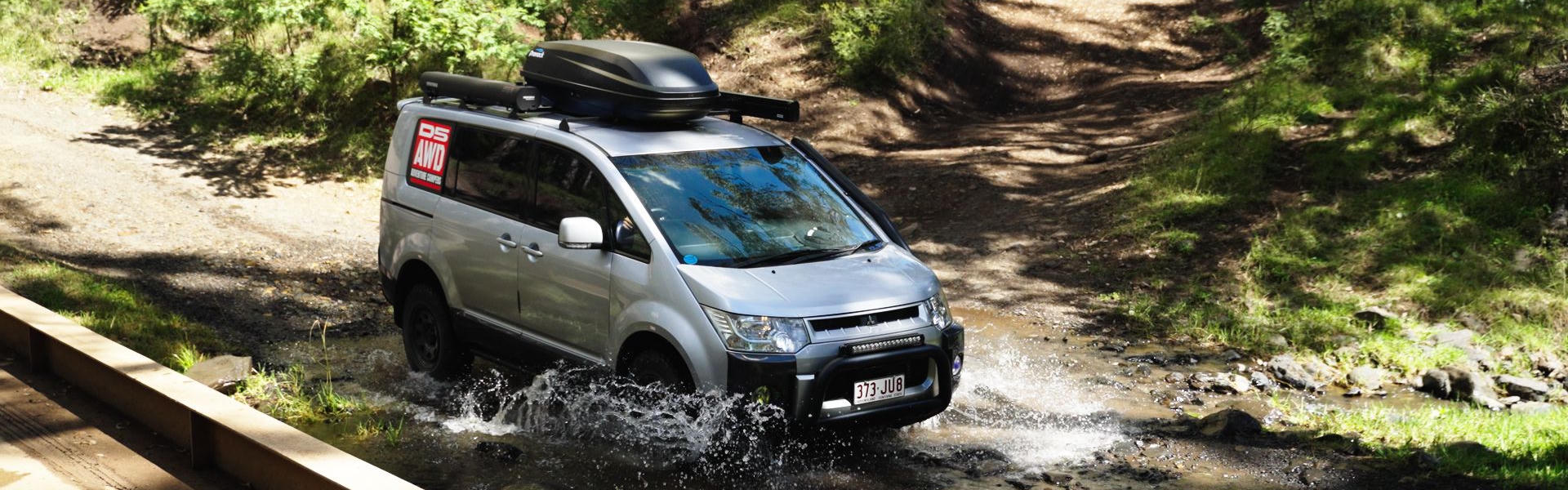 Camper im Wald fährt durch Wasser