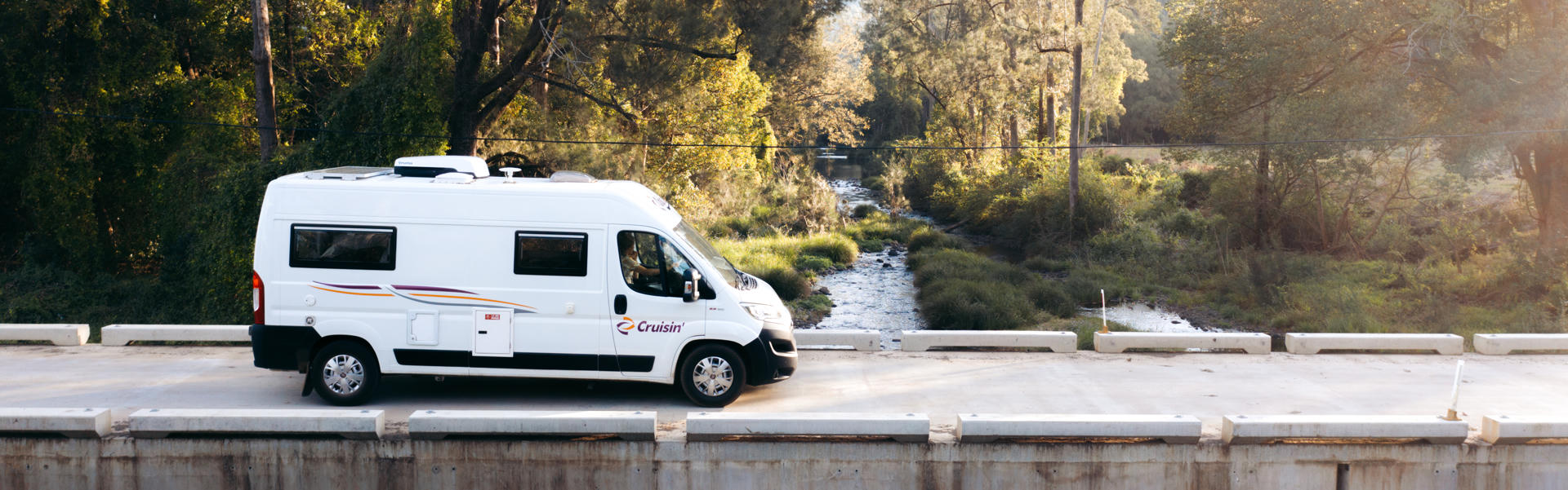 Der 2 Berth Sandpiper von Cruisin Motorhomes für 2 Personen über eine Brücke fahrend in Australien