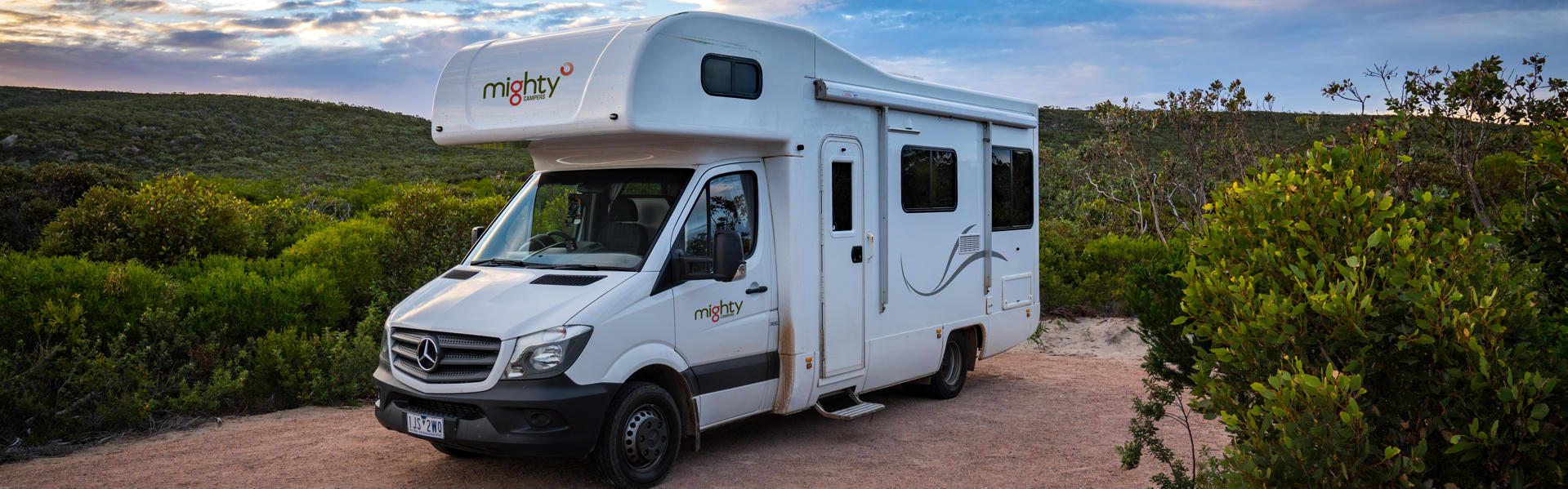 Double up 4 Bett Wohnmobil mit Markise von Mighty Campers geparkt zwischen Grün in Australien