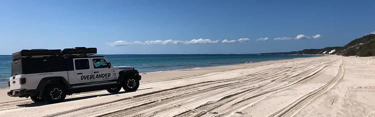 Camper fährt auf Sand am Meer