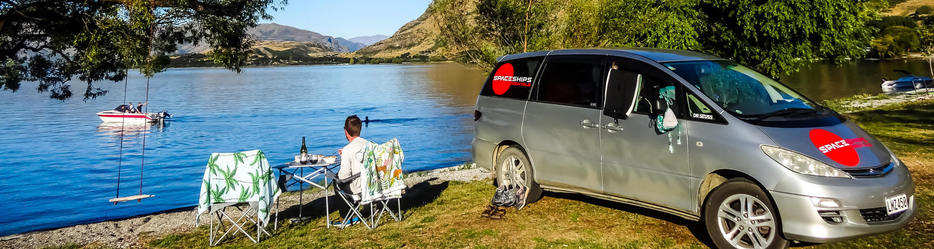 Camper steht am See und genießt die Natur