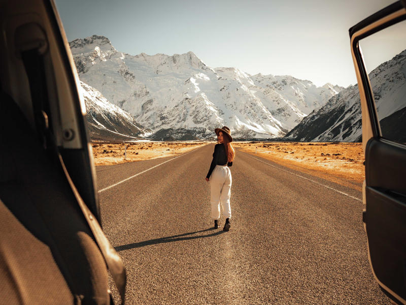 Junge Frau im Winter in Neuseeland vor ihem Camper