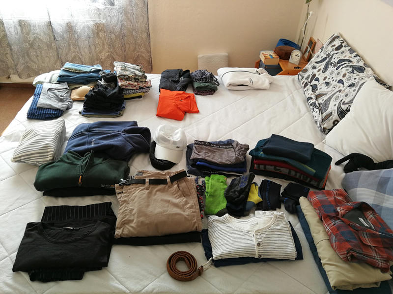Gefaltete Kleider auf einem Bett