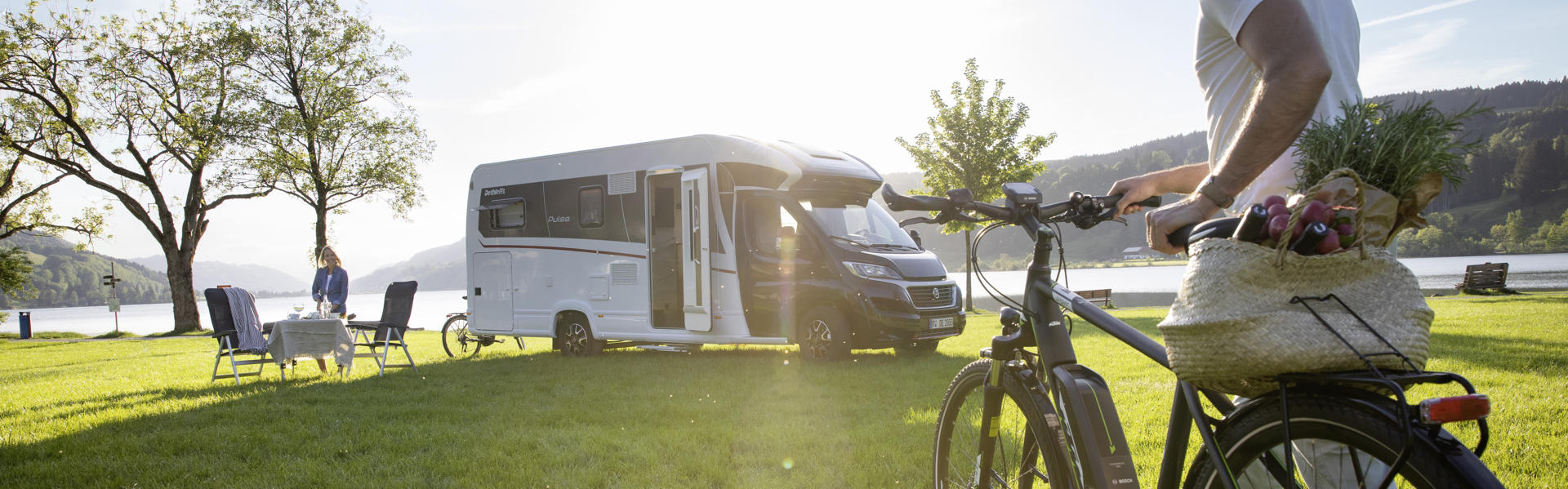 Comfort Plus vor See und Mensch mit Fahrrad