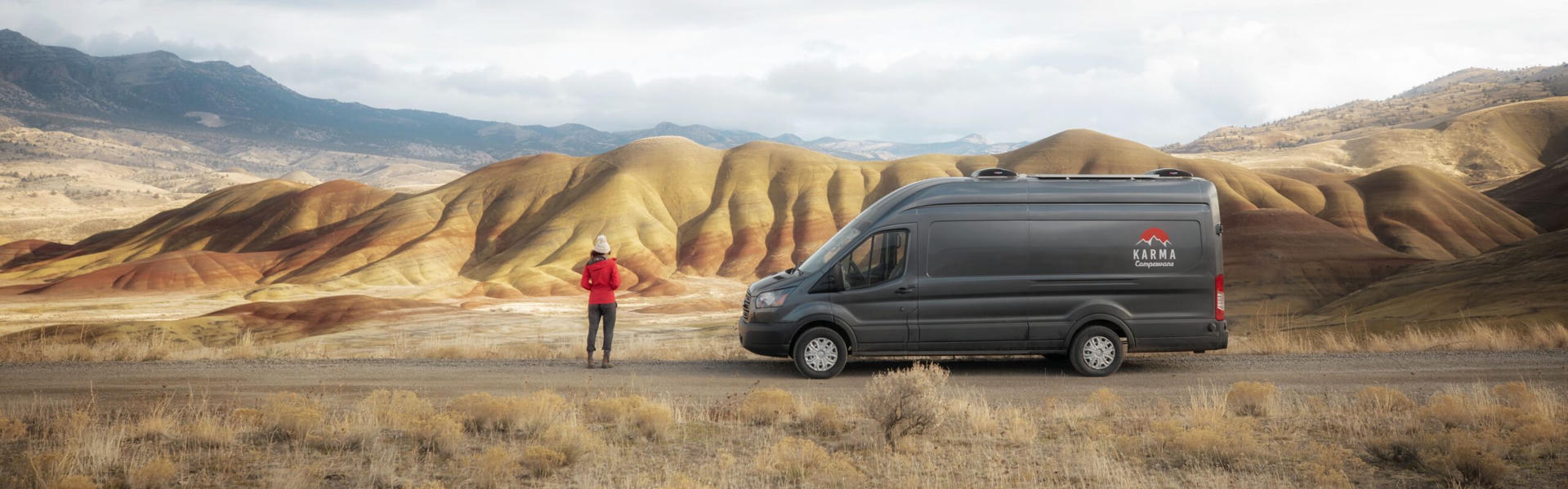 Camper von Karma Campervans auf einer Straße vor Bergen in Kanada