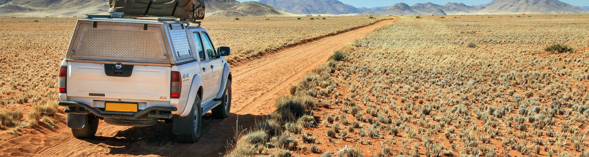 Camper mieten Namibia: Wohnmobil fährt in Namibia durch die Wüste