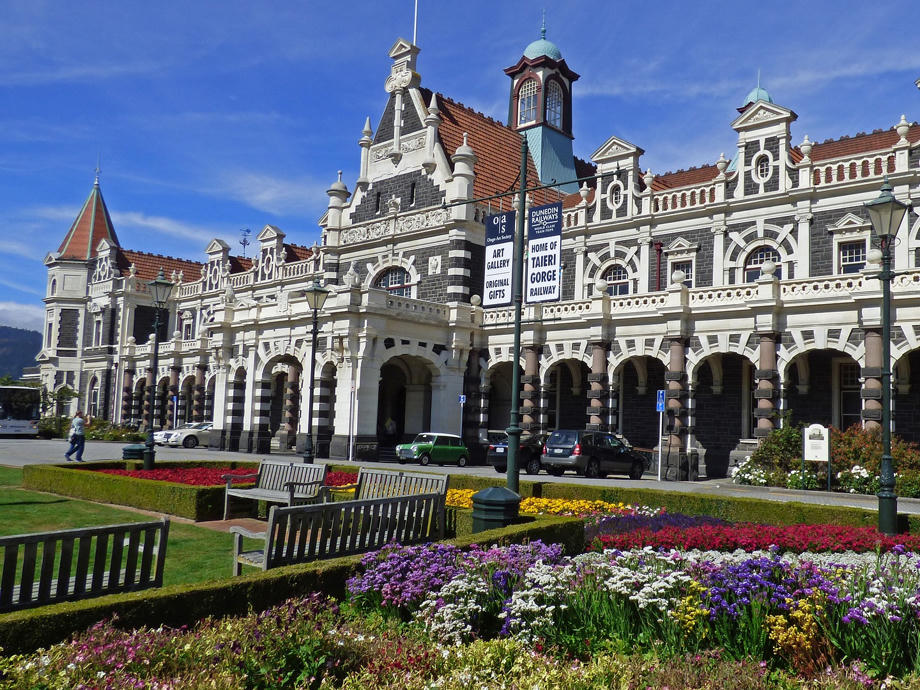 Der Bahnhof von Dunedin erstrahlt im Frühling und Sommer und bietet ein tolles Bild. Dunedin, Bahnhof, Blumenwiese