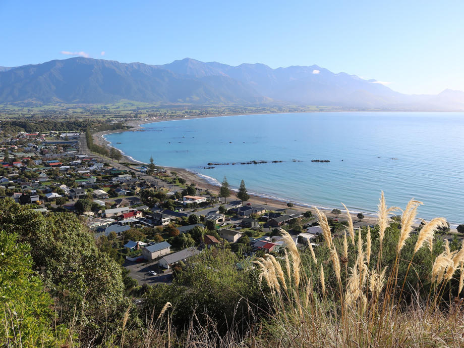 Der kleine Ort Kaikoura liegt wunderschöne pitturesk vor einer Bergkette in einer Bucht. Kaikoura, Ort, Neuseeland, Bergkette