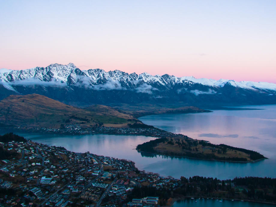 Queenstown bei Sonnenaufgang pitturesk inmitten der umliegenden Berggipfel. Queenstown, Halbinsel, Lake Wakatipu, Sonnenaufgang