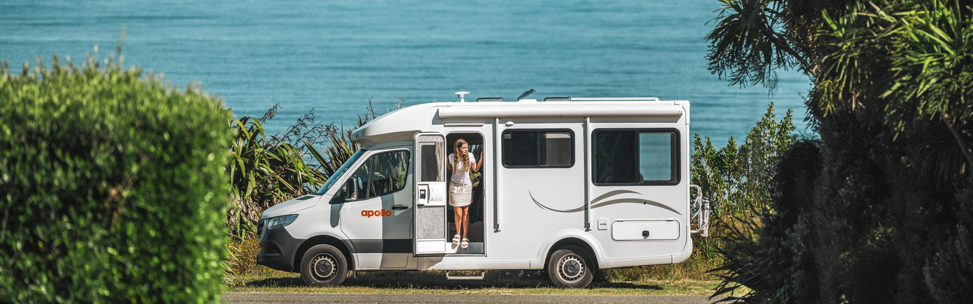 Euro Quest von Apollo Motorhomes mit offnener Tür vor See in Neuseeland