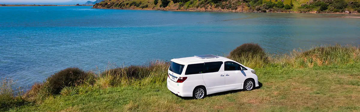 Der 2 Berth Sleepavanz von Discover NZ Motorhome Rentals an der Küste in Neuseeland