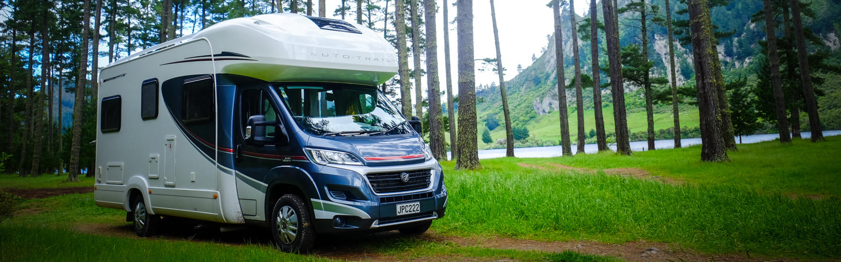 Wohnmobil von Discover NZ Motorhome Rentals in Neuseeland vor Bäumen