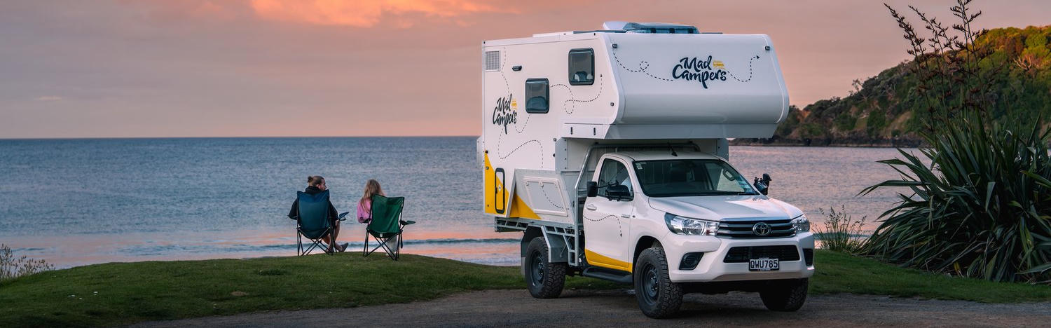 Hinteransicht des Campers auf einer Wiese