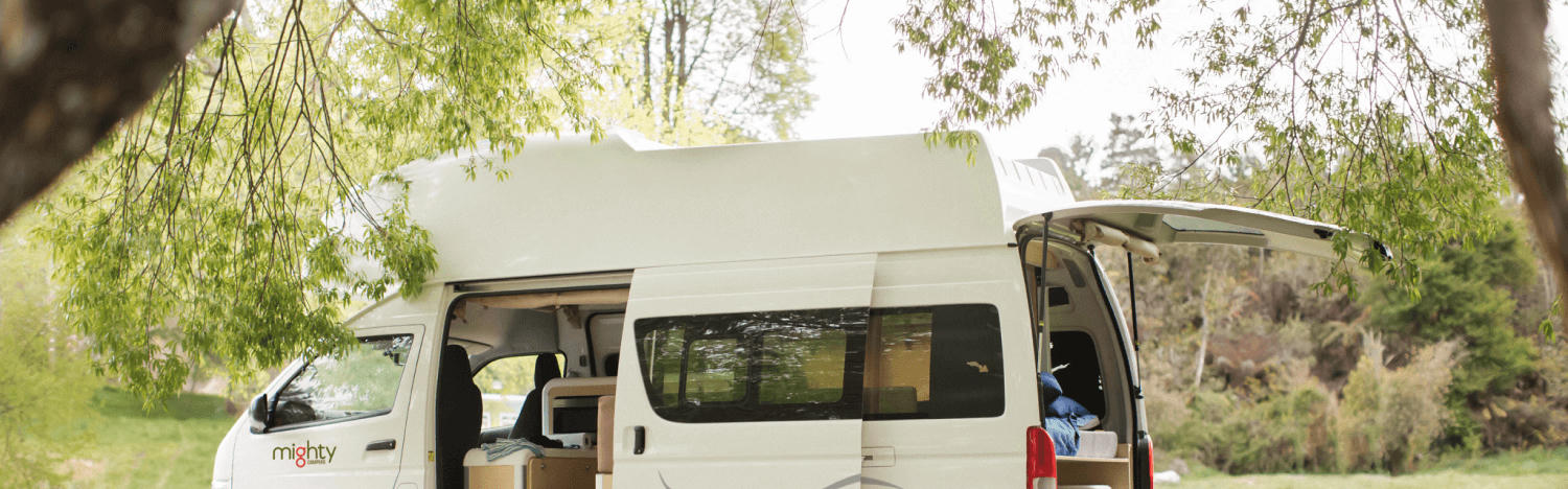 Highball Camper für 2 Personen von Mighty Campers geparkt in einem Wald in Neuseeland