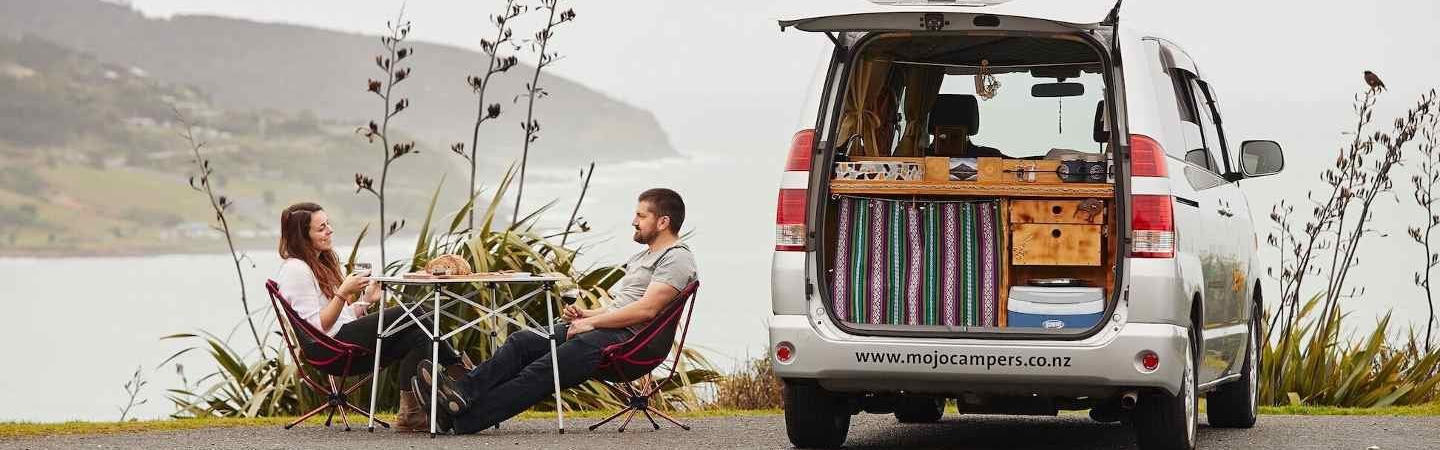 Camper von Mojo Campers geparkt an einer Küste in Neuseeland