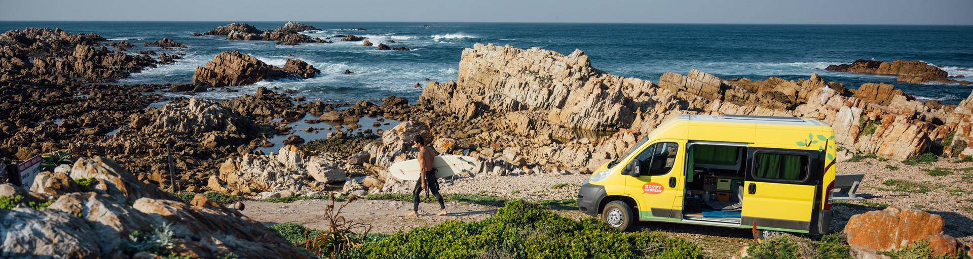 Camper und Surfer stehen vor Küste in Südafrika