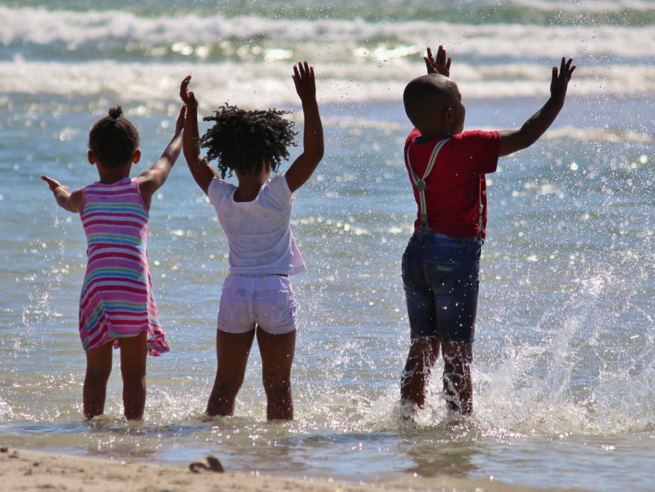 Circa 70% Prozent der südafrikanischen Bevölkerung sind trotz des großen europäischen Einflusses dunkelhäutig. Kinder, spielen, Wasser, Strand