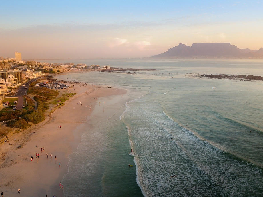 Unser Tipp: Nicht gen Süden, sondern von Kapstadt aus gen Norden fahren und die einsame Westküste erkunden. Strand, Kapstadt, Tafelberg, Surfer, Baden